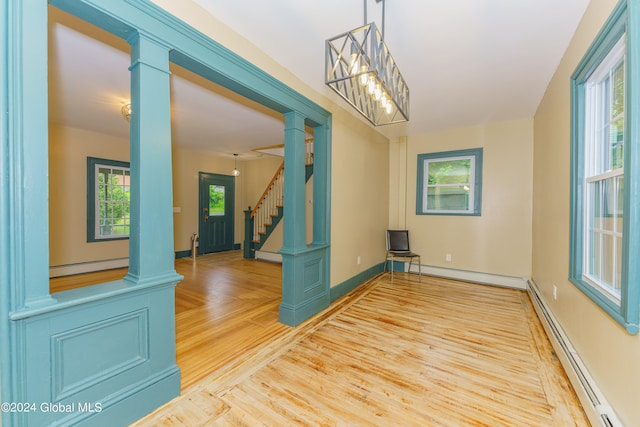 unfurnished dining area with light hardwood / wood-style floors and a baseboard heating unit