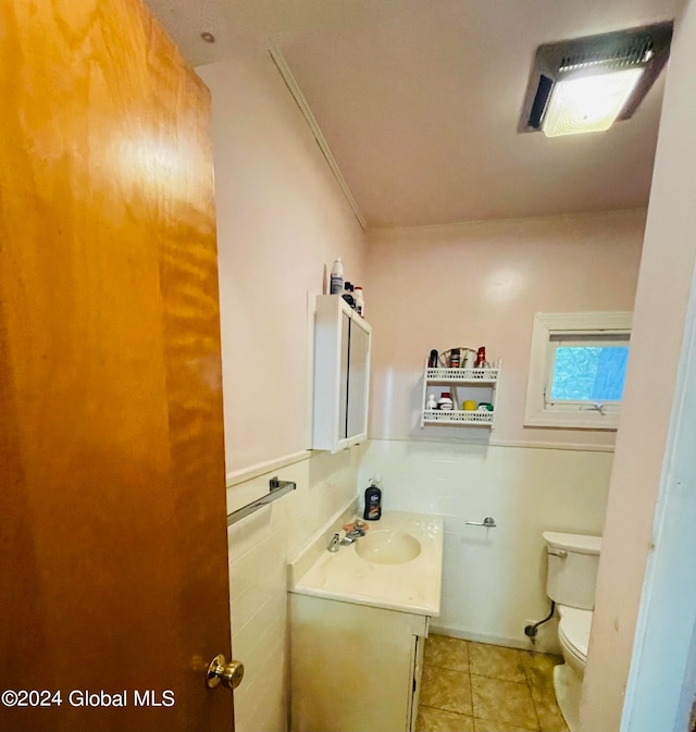 bathroom with tile patterned flooring, ornamental molding, vanity, and toilet