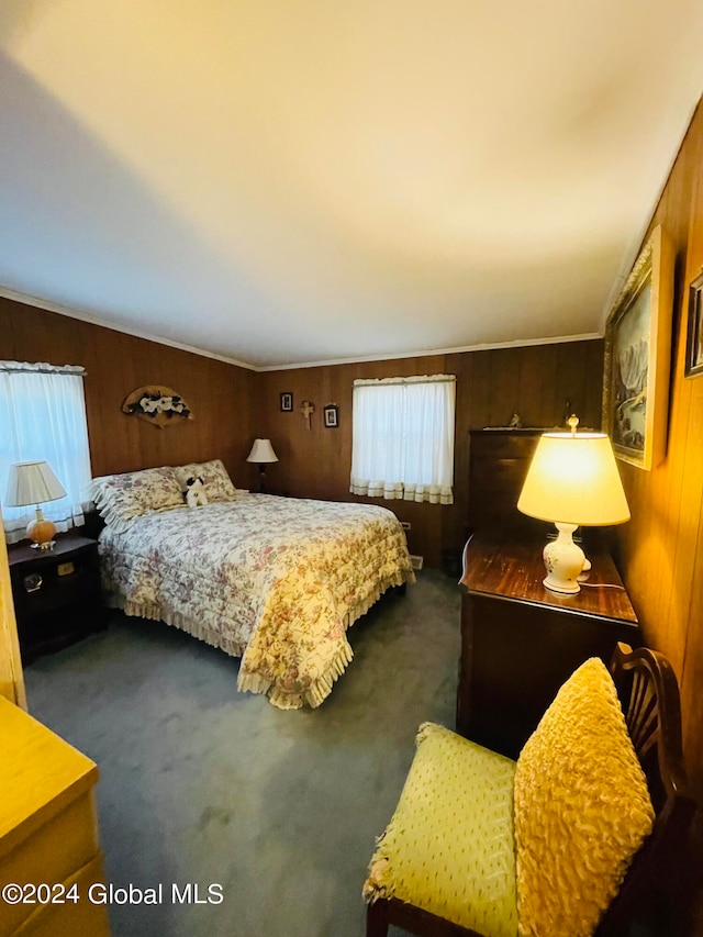 bedroom with dark carpet and wooden walls