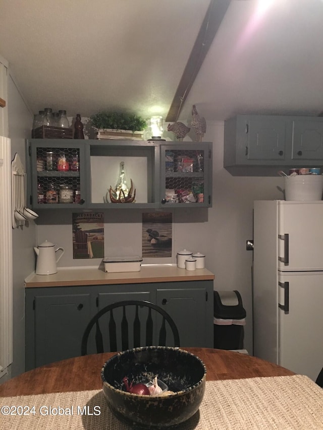 kitchen featuring gray cabinetry, beamed ceiling, and white refrigerator