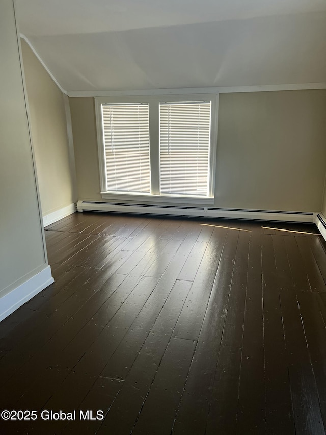 empty room featuring baseboard heating, dark hardwood / wood-style floors, and a wealth of natural light