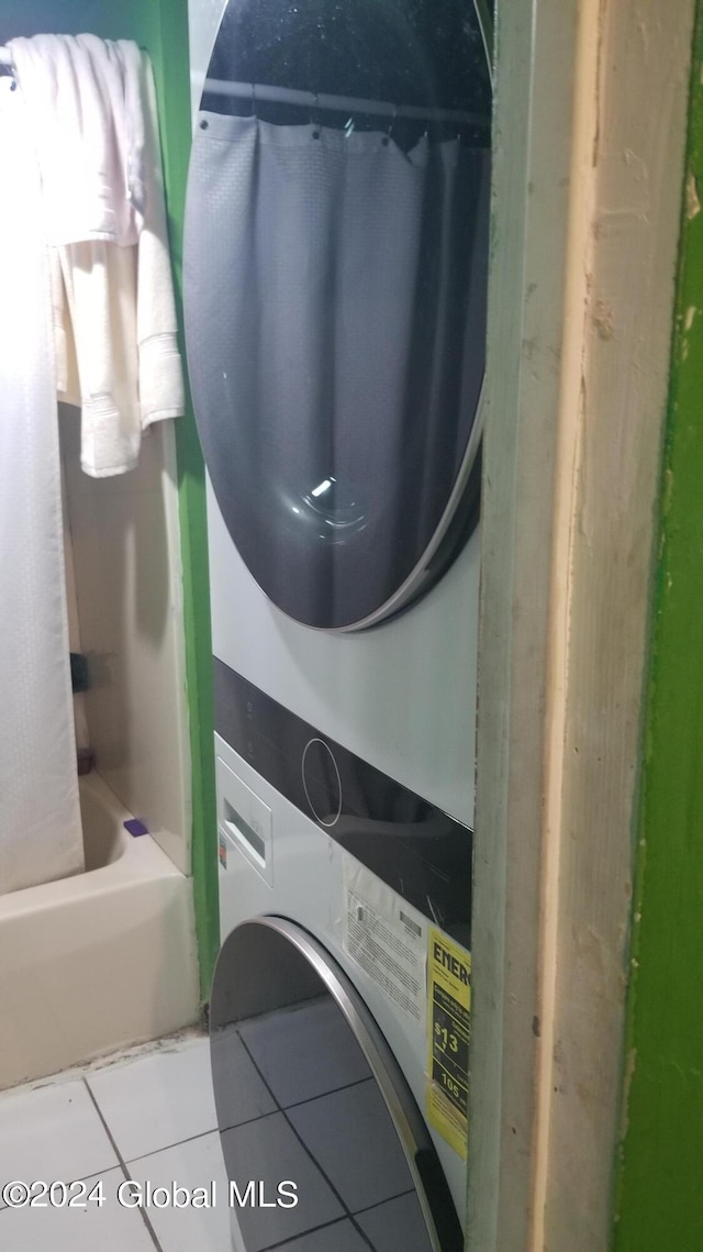 clothes washing area with tile patterned floors and stacked washing maching and dryer