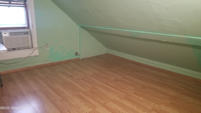 bonus room with light hardwood / wood-style flooring, cooling unit, and lofted ceiling