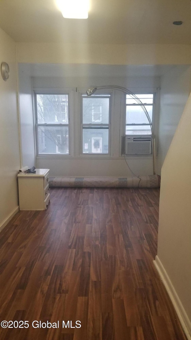 additional living space with cooling unit and dark wood-type flooring