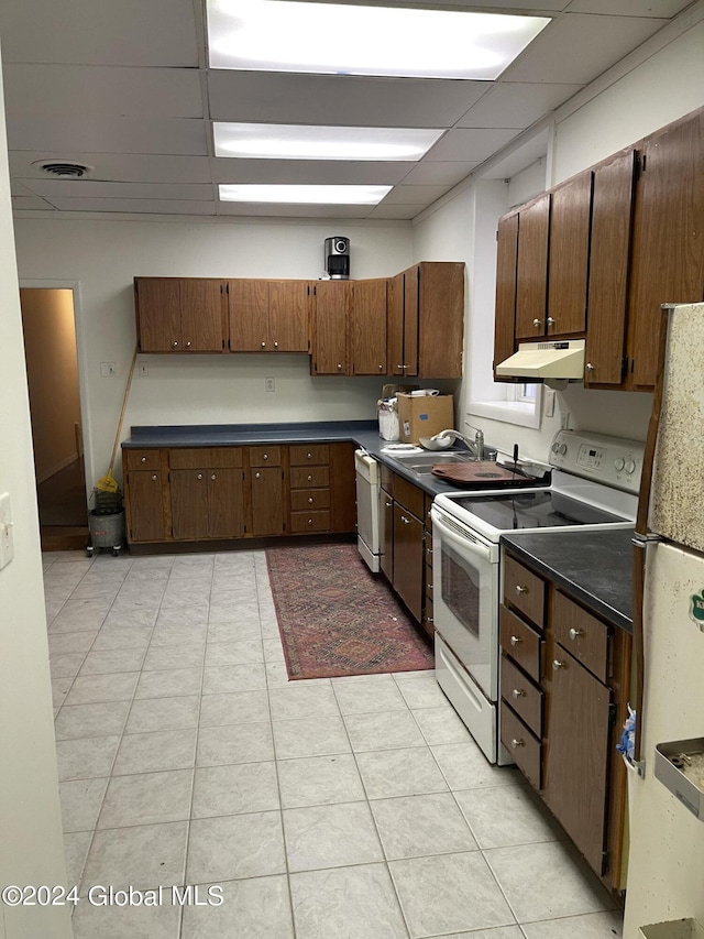 54 3rd St, Waterford, NY 12188 - kitchen with white appliances, a drop ceiling, under cabinet range hood, dark countertops, and a sink