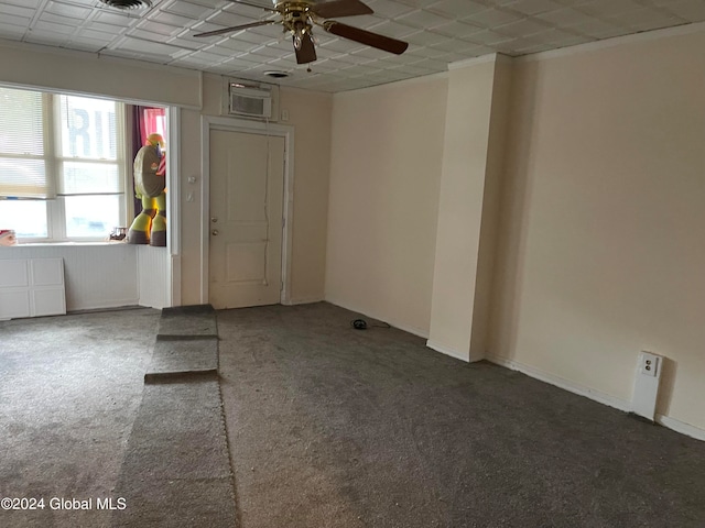 carpeted empty room with an AC wall unit and ceiling fan