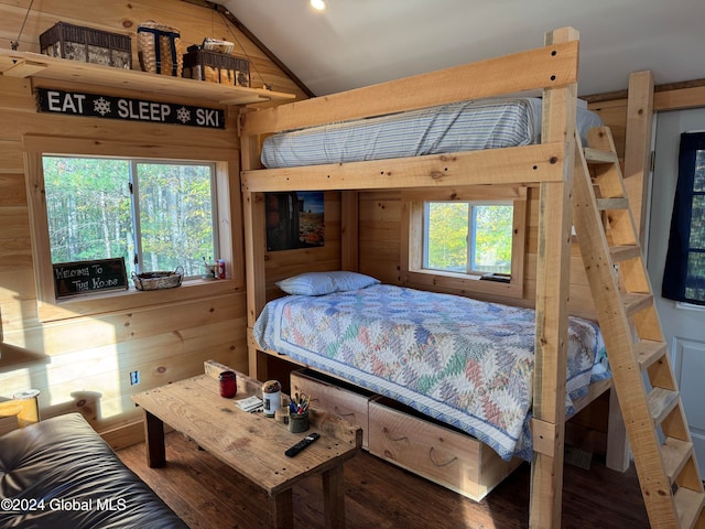 bedroom featuring wood walls, vaulted ceiling, and hardwood / wood-style flooring