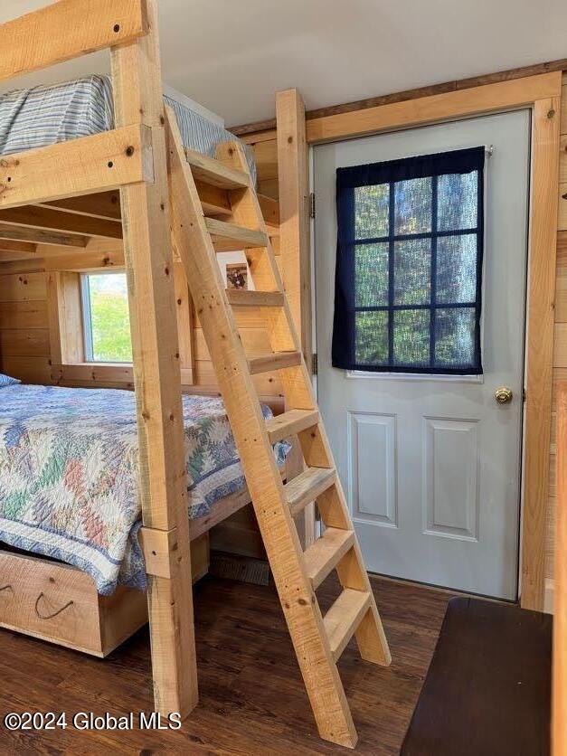 bedroom with dark hardwood / wood-style floors and multiple windows