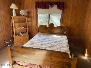 bedroom featuring wooden walls