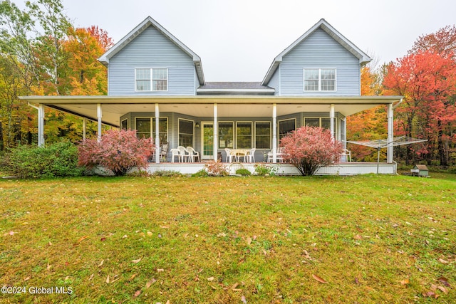 rear view of house with a yard, a sunroom, and ceiling fan