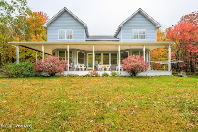 rear view of house featuring a porch and a yard