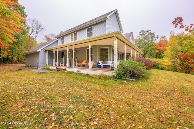 rear view of house with a porch and a lawn