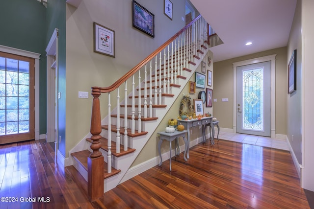 foyer entrance with stairway, hardwood / wood-style flooring, and baseboards