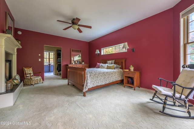 carpeted bedroom featuring ceiling fan and a glass covered fireplace