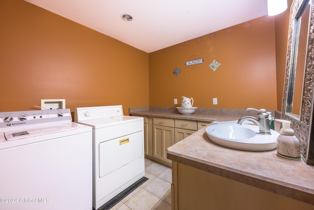 clothes washing area with light tile patterned floors, washer and dryer, and a sink