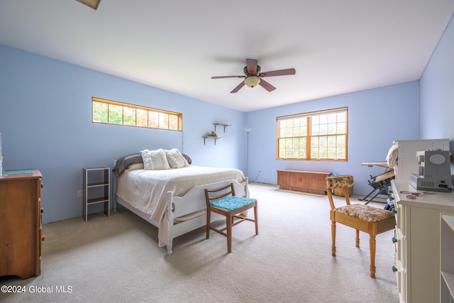 bedroom featuring ceiling fan, carpet floors, and multiple windows
