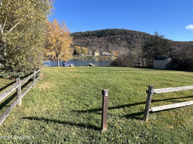 view of yard with a storage unit and a water and mountain view