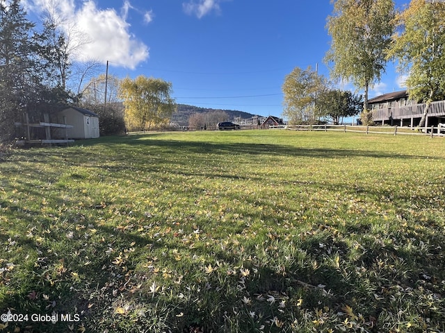 view of yard featuring a rural view and a storage unit