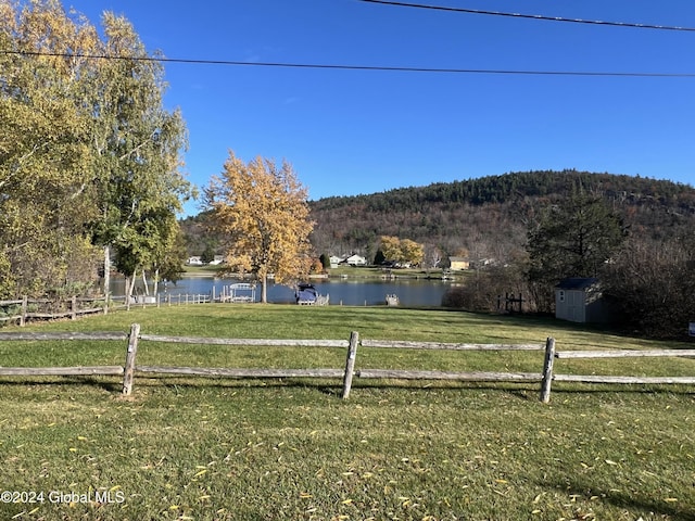 view of yard featuring a water and mountain view and a rural view