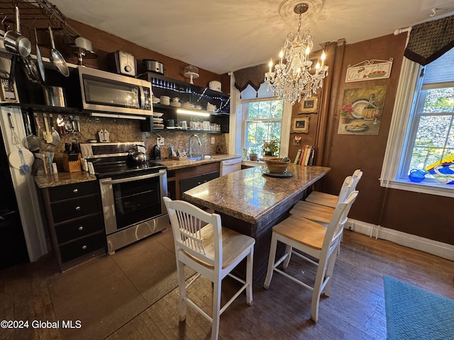 interior space with a sink, open shelves, appliances with stainless steel finishes, and a healthy amount of sunlight
