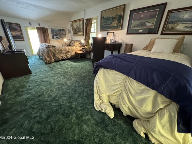 bedroom with carpet floors and lofted ceiling