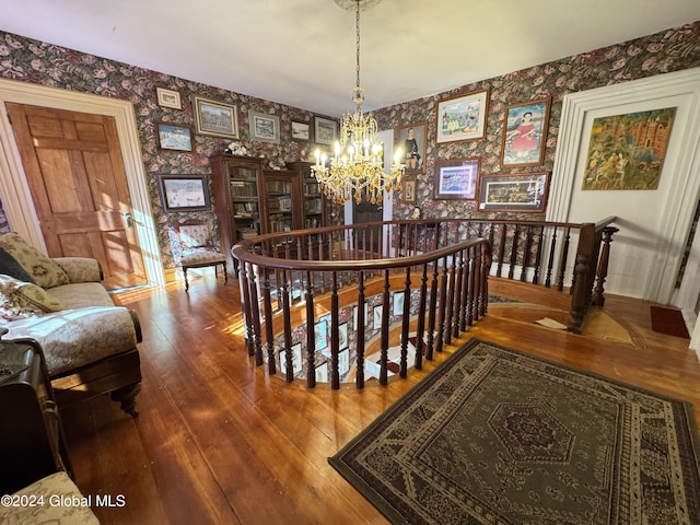 dining area featuring hardwood / wood-style floors, a notable chandelier, and wallpapered walls