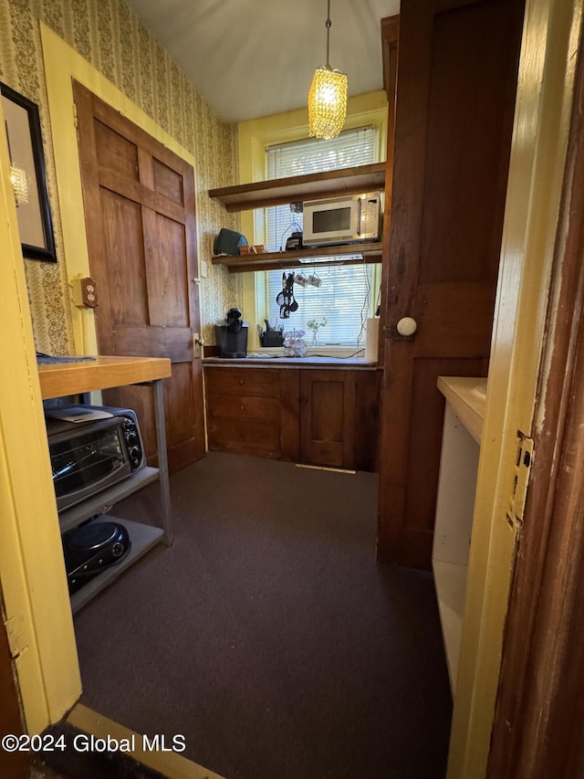 interior space featuring wallpapered walls and carpet floors