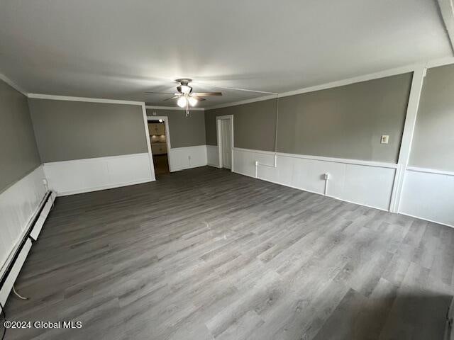 spare room with crown molding, a baseboard radiator, and dark hardwood / wood-style flooring