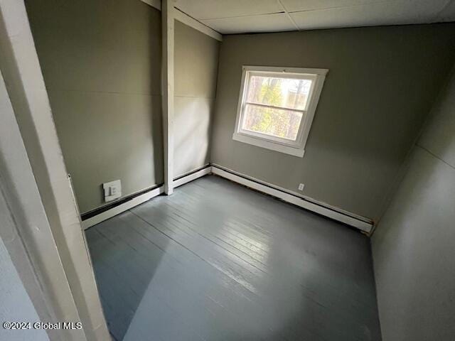 empty room featuring a paneled ceiling and baseboard heating