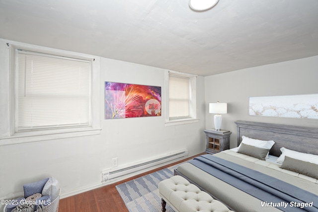 bedroom with a baseboard radiator, baseboards, and wood finished floors