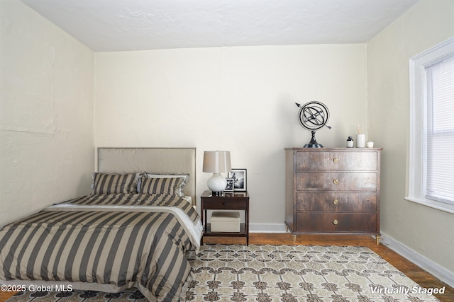 bedroom featuring baseboards and wood finished floors