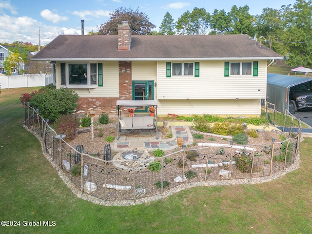 back of property with a lawn and a carport