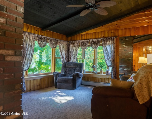 interior space featuring wood walls, ceiling fan, a healthy amount of sunlight, and carpet flooring