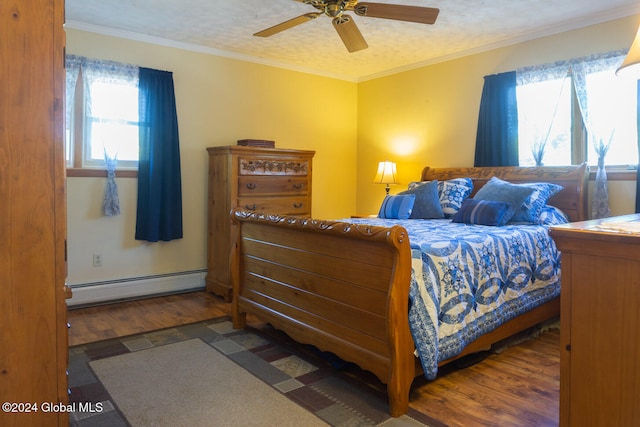 bedroom with baseboard heating, a textured ceiling, ceiling fan, crown molding, and dark wood-type flooring