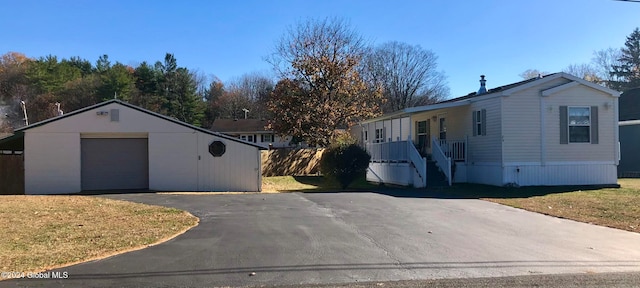 view of front of property featuring an outbuilding, a garage, and a front yard