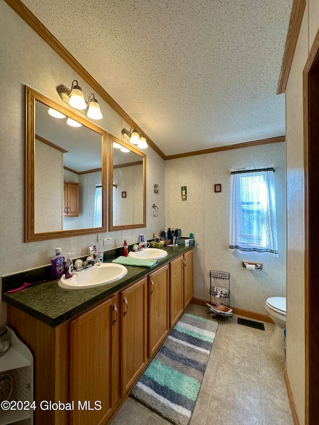 bathroom with crown molding, vanity, a textured ceiling, and toilet