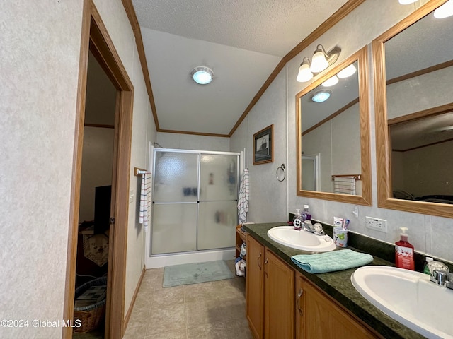 bathroom with ornamental molding, a textured ceiling, vanity, a shower with shower door, and vaulted ceiling