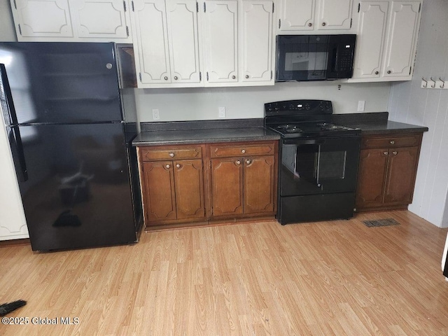 kitchen with white cabinetry, black appliances, and light wood-type flooring