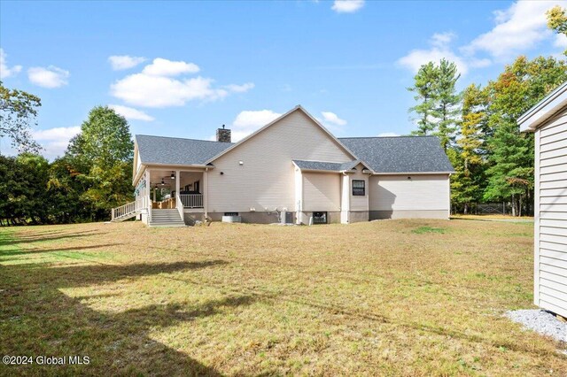 rear view of house with a lawn and a porch