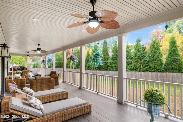 wooden deck with ceiling fan, a lawn, and outdoor lounge area