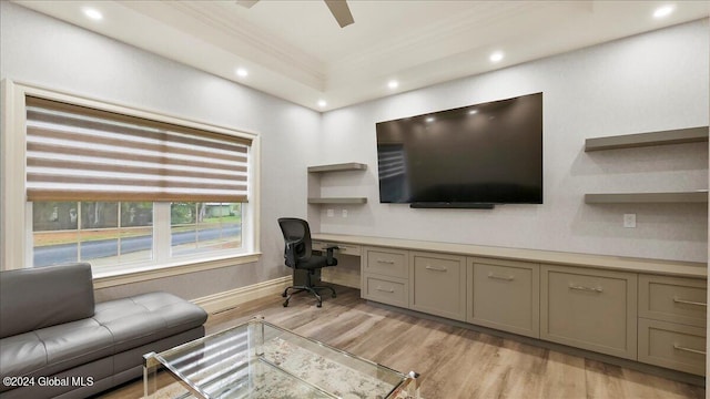 office space with built in desk, crown molding, light hardwood / wood-style floors, and ceiling fan