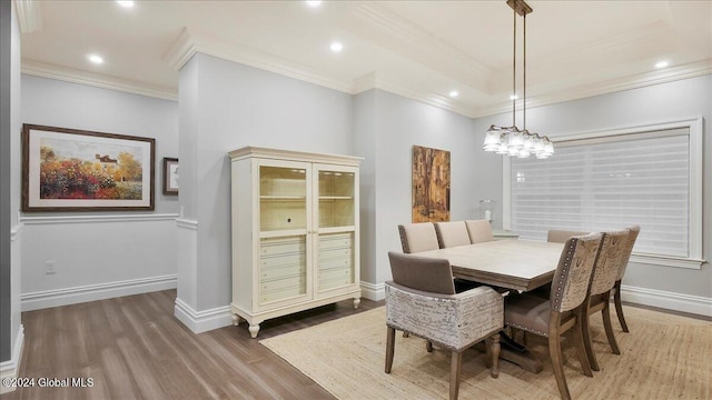 dining room featuring crown molding, wood-type flooring, and an inviting chandelier