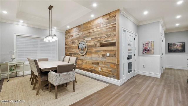 dining area with crown molding, light hardwood / wood-style flooring, and an inviting chandelier