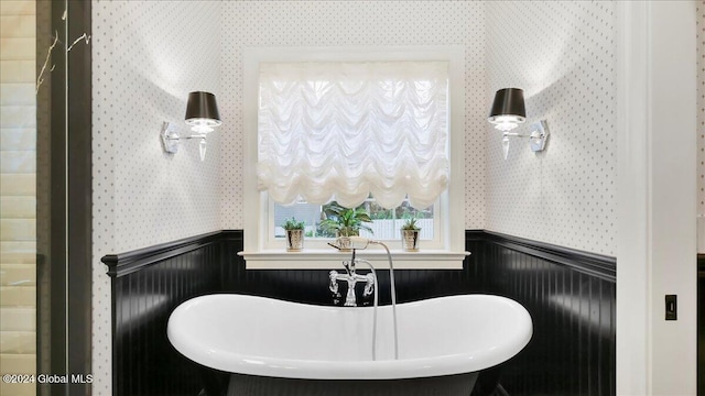 bathroom with a bathtub, sink, and wooden walls