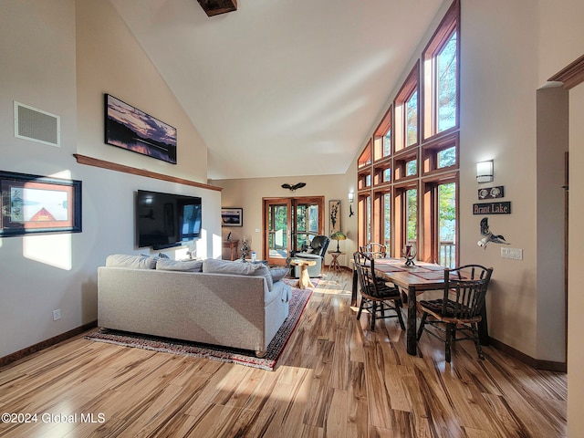 living room featuring high vaulted ceiling and hardwood / wood-style flooring