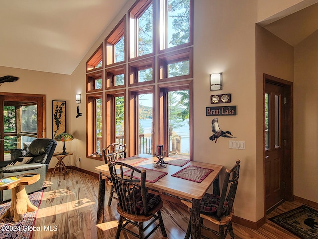 dining room featuring hardwood / wood-style flooring and high vaulted ceiling