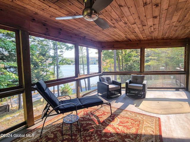 sunroom / solarium with ceiling fan, wood ceiling, plenty of natural light, and a water view