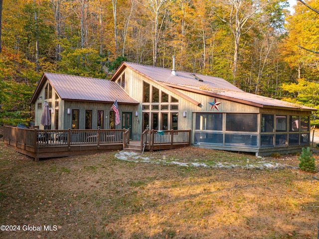 back of house featuring a sunroom and a wooden deck