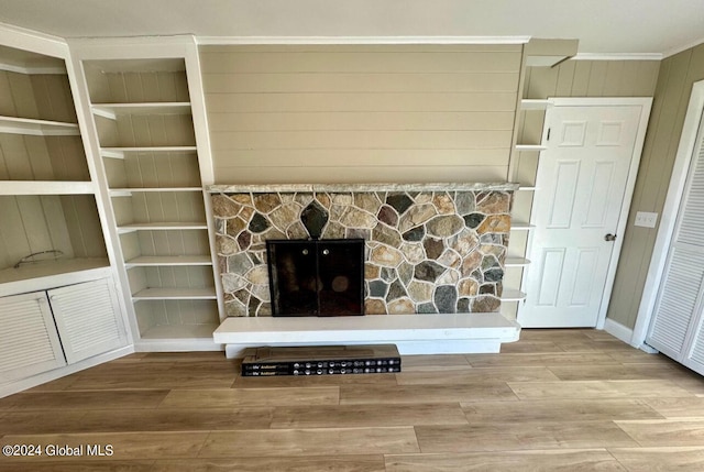 living room with hardwood / wood-style flooring, a fireplace, and wood walls