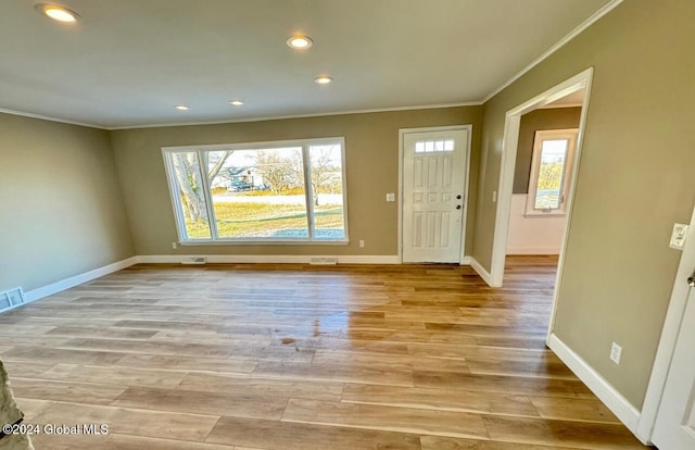 foyer featuring ornamental molding and light hardwood / wood-style flooring